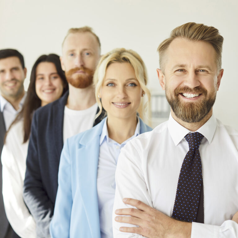 Trainer in einem professionellen Business-Outfit mit einer Gruppe von Fachleuten, die an einer Besprechung teilnehmen
