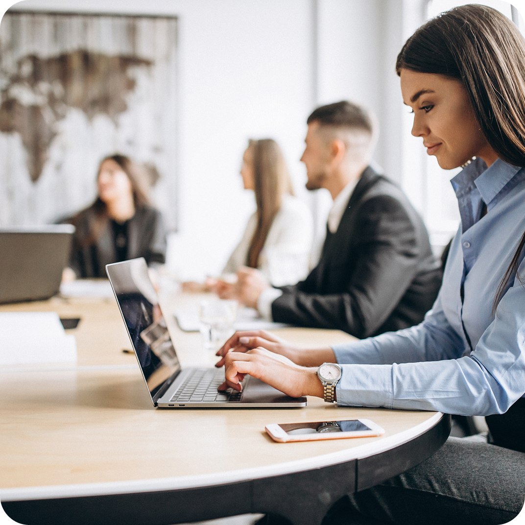 Gruppe von fünf professionellen Mitarbeitenden, die in einem modernen Bürogebäude zusammenarbeiten und sich austauschen